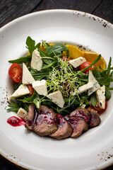 delicious salad in a plate on a dark table
