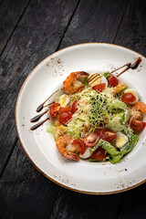 delicious salad in a plate on a dark table
