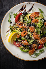 delicious salad in a plate on a dark table
