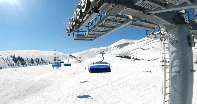 First person view POV of ski lift ride. Skiing on snow slopes in the mountains
