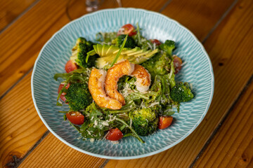 tasty salad in a plate on a brown table
