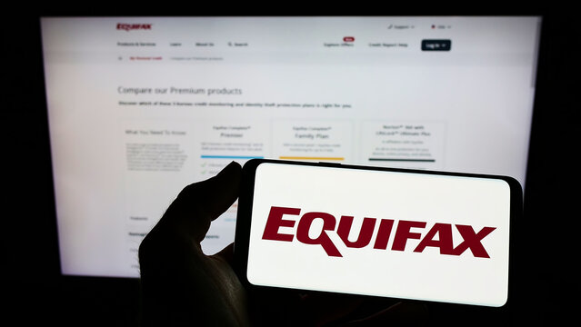 Stuttgart, Germany - 10-01-2022: Person holding cellphone with logo of US consumer credit reporting company Equifax Inc. on screen in front of webpage. Focus on phone display.