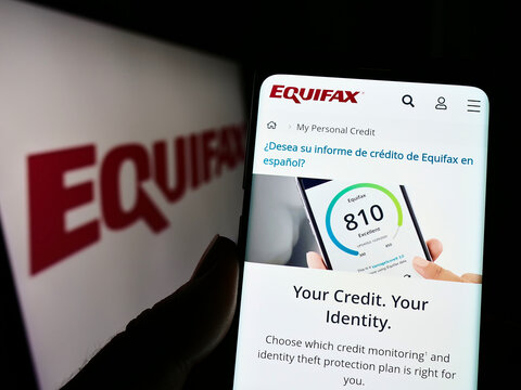 Stuttgart, Germany - 10-01-2022: Person holding mobile phone with website of consumer credit reporting company Equifax Inc. on screen with logo. Focus on center of phone display.