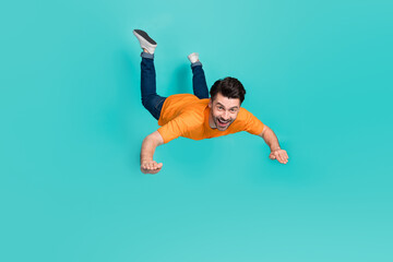 Full body photo of crazy guy playing air gliding flying isolated on cyan color background