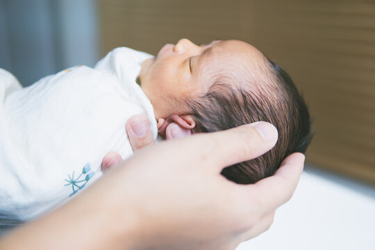 close up picture of Newborn baby on hand father's for shower. 