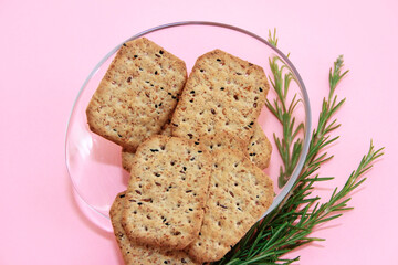 Dry square diet crackers with black cumin seeds and quinoa in a decorative plate