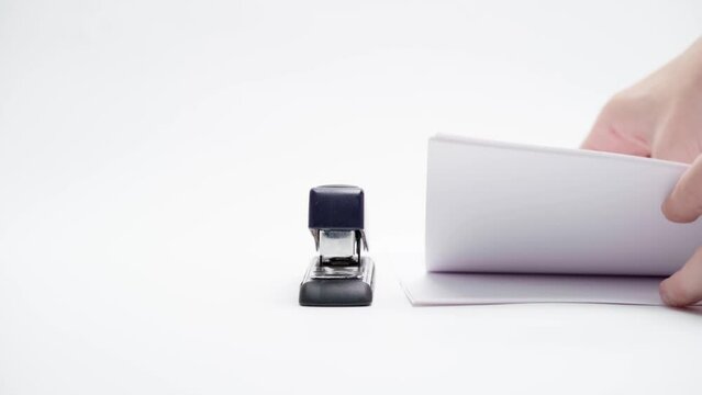 A man fastens paper with a stapler, close-up, only his hands are in the frame, on a white background, isolated