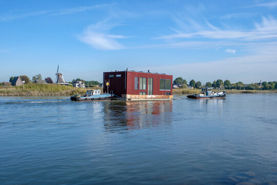 Transport of a houseboat on the IJssel near Veessen, Gelderland province, The Netherlands || Transport van woonboot over de IJssel bij Veessen, Geldelrland province, The Netherlands