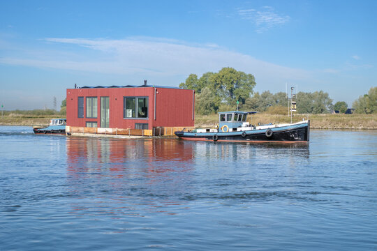 Transport of a houseboat on the IJssel near Veessen, Gelderland province, The Netherlands || Transport van woonboot over de IJssel bij Veessen, Geldelrland province, The Netherlands