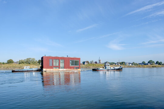 Transport of a houseboat on the IJssel near Veessen, Gelderland province, The Netherlands || Transport van woonboot over de IJssel bij Veessen, Geldelrland province, The Netherlands