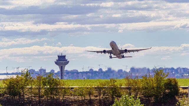 Great plane taking off and taking height next to the control tower of the airport, Madrid, Spain.
