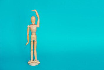 yellow wooden mannequin poses and gestures with his hands on a blue background