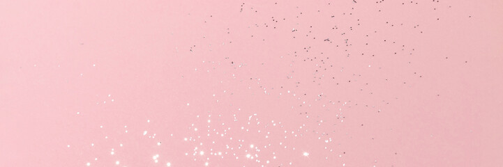 Sparkling silver glitter on pink background banner texture. Abstract holiday blurred lights header. Wide screen wallpaper. Panoramic web banner with copy space for design