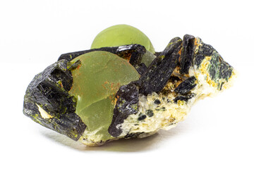 Chunk of real green prehnite spheres and dark green almost black epidote spikes on matrix macro isolated on white surface 