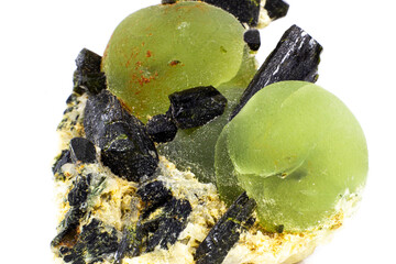 Chunk of real green prehnite spheres and dark green almost black epidote spikes on matrix macro isolated on white surface 