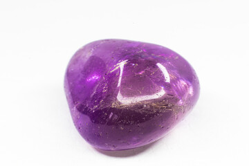 Real tumbled Ametrine stone macro isolated on white surface. Purple crystal with a bit of yellow coloration on the end.