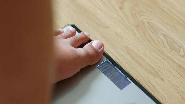 Closeup fat man step on scales to measure weight