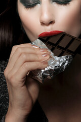 beautiful young brunette girl eating chocolate - 537556542