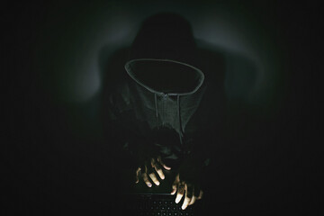 Fototapeta na wymiar Computer hacker with a laptop in darkness