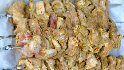 Closeup on a bunch of ready-to-eat shishlik kebabs piled on the picnic grill.