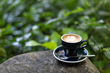 cappuccino coffee placed on shady corner garden