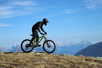 Fototapeta na wymiar a mountain biker on the summit in the snowy alps