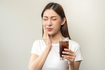 Health asian young woman touching her mouth, expression, suffering from toothache, decay or sensitivity cavity molar tooth or inflammation drink cold, sparkling water at home.Sensitive teeth people.