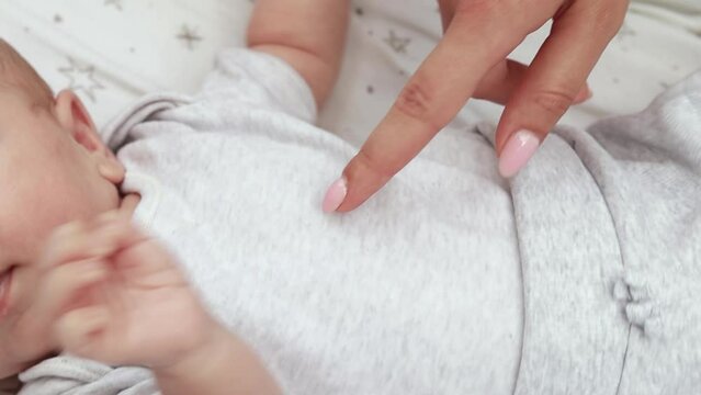 1080p slow motion footage video. Close up newborn baby child lying in baby carriage stroller buggy having fun playing, looking at her mother, smiling infant. Outside walking in pushchair, fresh air


