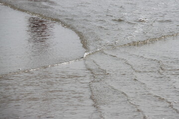 outgoing shallow waves on the beach of the north sea