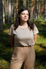 Fototapeta premium Woman walks in summer in pine forest.