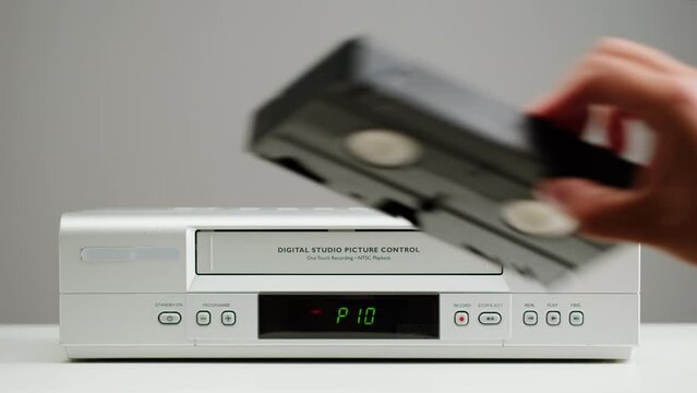 Old video recorder close-up, VHS. Retro player, vintage video cassette broadcasting on grey background, audio tape. 
