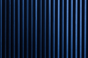 Minimalist art picture: black pencils next to each other with blue color light form vertical dark lines. Artistic, elegant design structure photo for graphics, backgrounds.