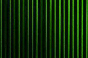 Minimalist abstract art picture: black pencils next to each other with green color light form vertical dark lines. Artistic, elegant design structure photo for graphics, background.
