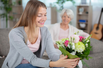 daughter giving flowers to her mom