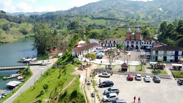 South America, Colombia august 2022  , Drone aerial view  El Pe&ntilde;&oacute;n de Guatap&eacute;  church cathedral in downtown of little colonial village close to Medellin - Antioquia tourist attraction lake 