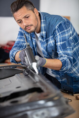 young coachbuilder mechanic straightening car