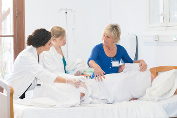 nurses practicing how to roll a patient with dummy