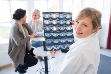 portrait of young female doctor holding sheet of xrays