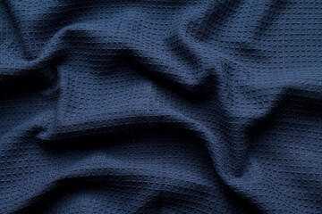Fototapeta na wymiar Close-up abstract texture dark blue color fabric cloth textile background, cotton wavy material, soft folds waves on the fabric. Macro, web theme, template, wallpaper, concept design, for your design