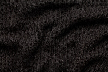 Close-up abstract texture black color fabric cloth textile background, knitted wool wavy material, soft folds waves on the fabric. Macro, web theme, template, wallpaper, concept design, in detail