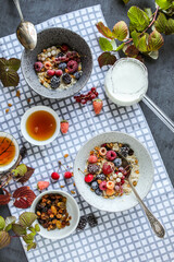 Oatmeal with raisins and frozen berries on a dining table with a checkered napkin.