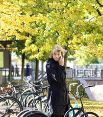 young man walking in the park, riding a bicycle on a warm sunny autumn day