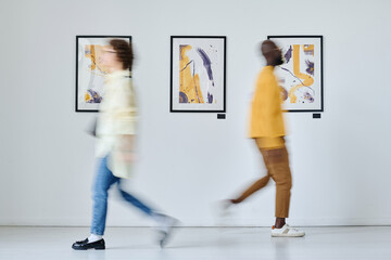 Blurred motion of young people walking along art gallery - obrazy, fototapety, plakaty