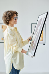 Gallery worker working with modern art in art gallery preparing for exhibition