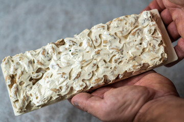 male hands holding a nougat piece