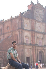 Fototapeta na wymiar man posing infront of old goa chruch