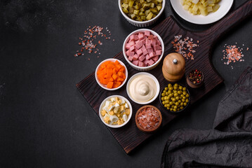 Delicious fresh Olivier salad with sausage, egg, cucumber, green peas, carrots and mayonnaise
