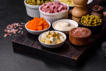 Delicious fresh Olivier salad with sausage, egg, cucumber, green peas, carrots and mayonnaise
