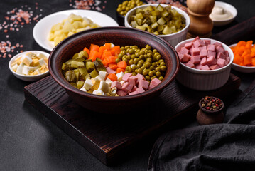 Delicious fresh Olivier salad with sausage, egg, cucumber, green peas, carrots and mayonnaise