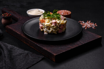 Fototapeta na wymiar Delicious fresh Olivier salad with sausage, egg, cucumber, green peas, carrots and mayonnaise